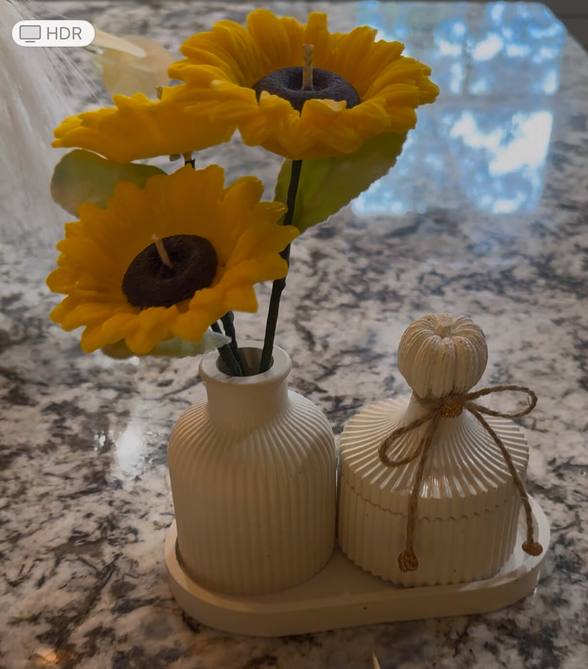 Sunflower candle arrangement — three yellow sunflower candles in ribbed ceramic vase with matching lidded jar on tray