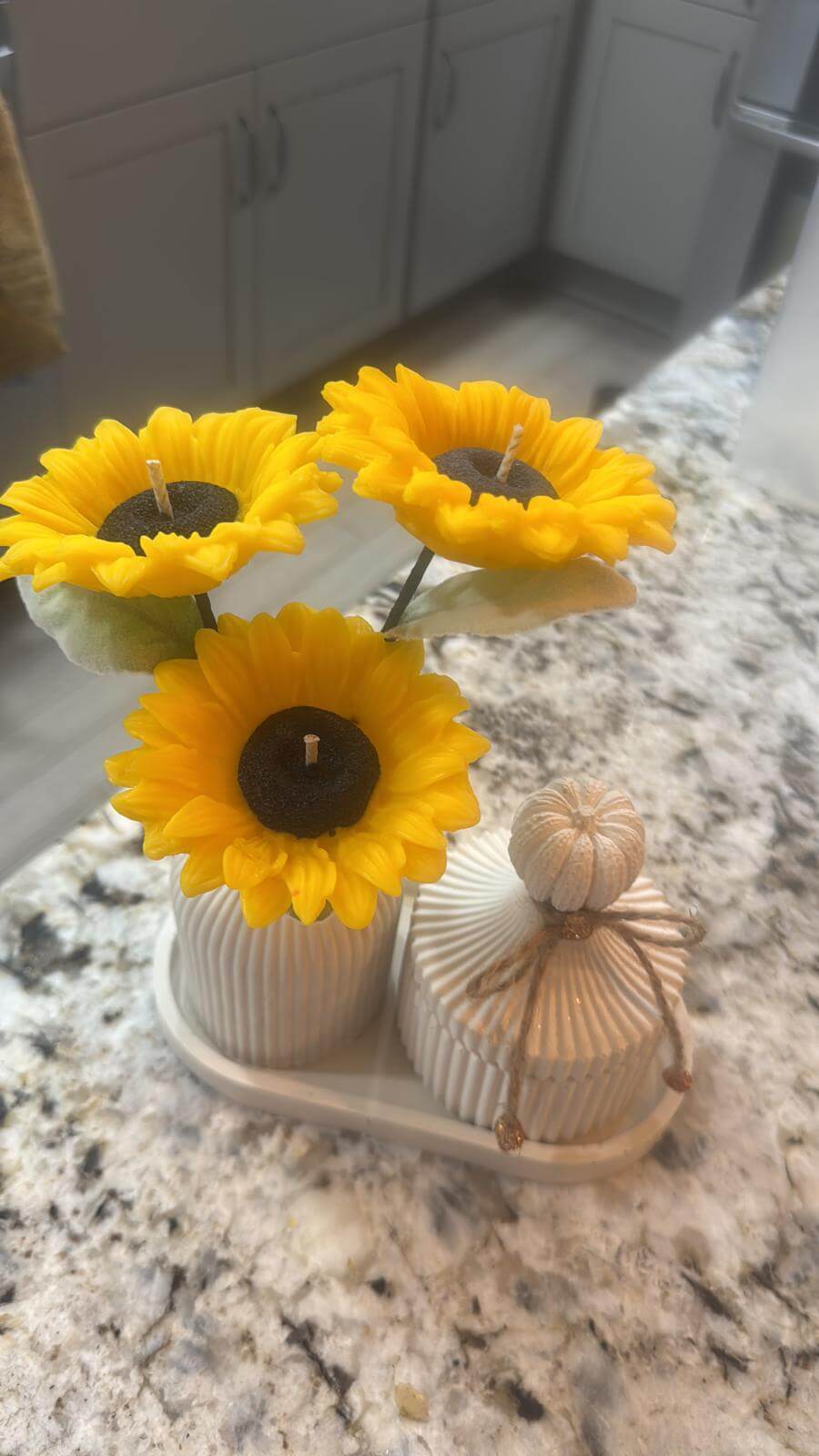 Sunflower candle arrangement — three yellow sunflower candles in ribbed ceramic vase with matching lidded jar on tray