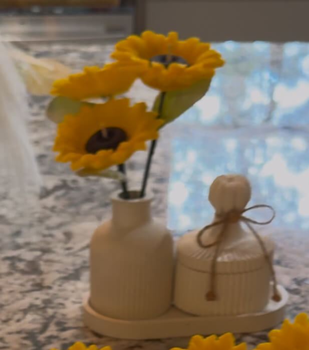 Sunflower candle arrangement — three yellow sunflower candles in ribbed ceramic vase with matching lidded jar on tray