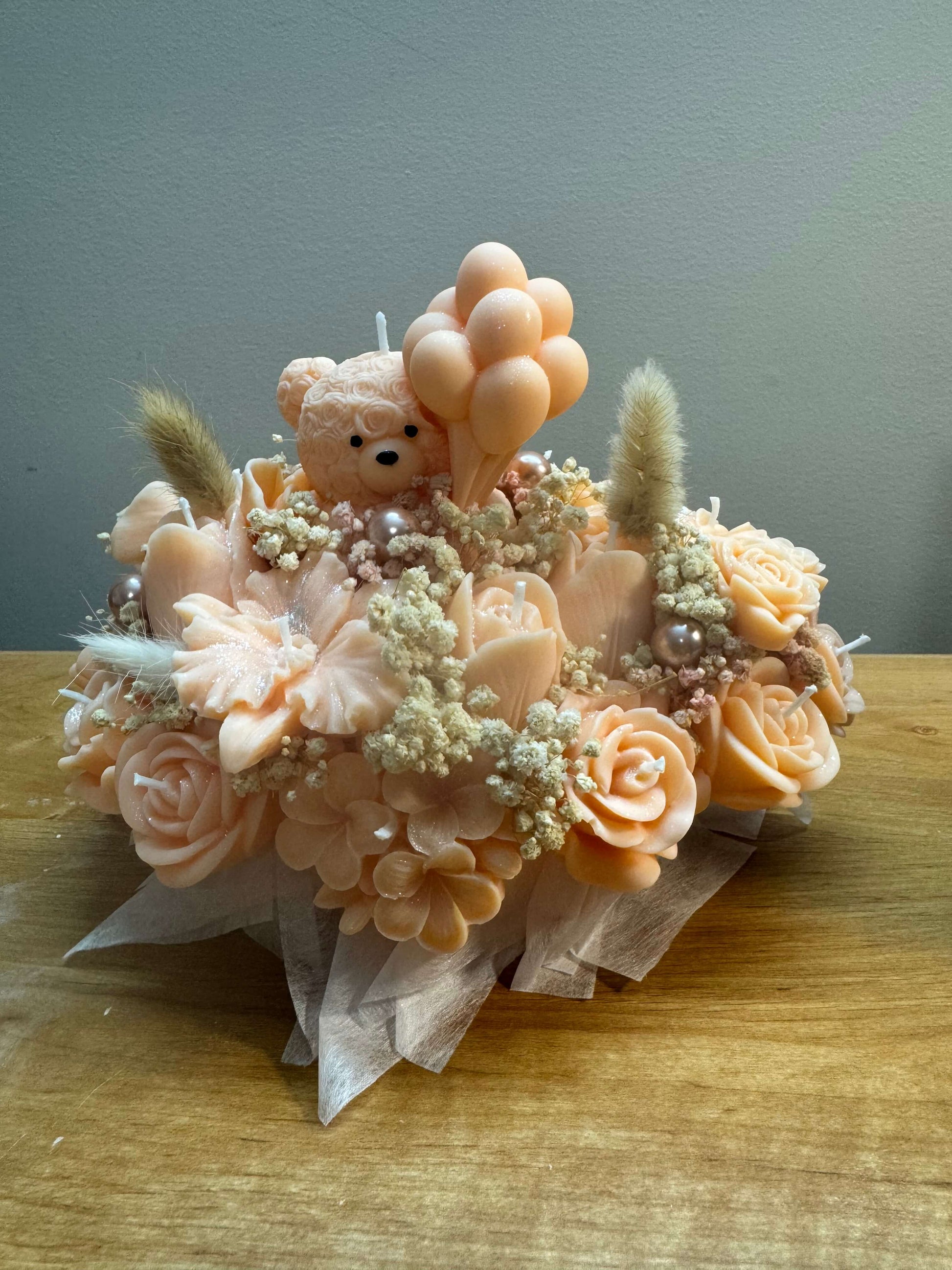 Handmade peach floral candle bouquet with teddy bear detail in ceramic base