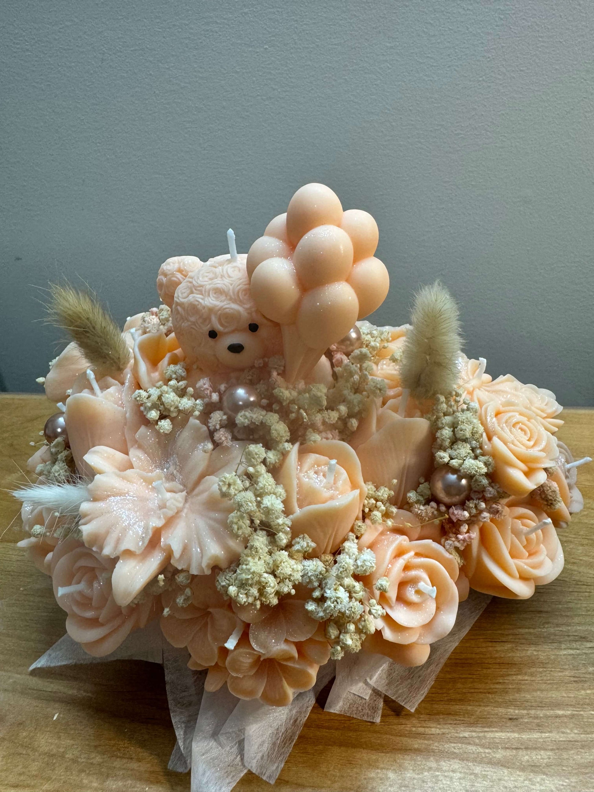 Handmade peach floral candle bouquet with teddy bear detail in ceramic base