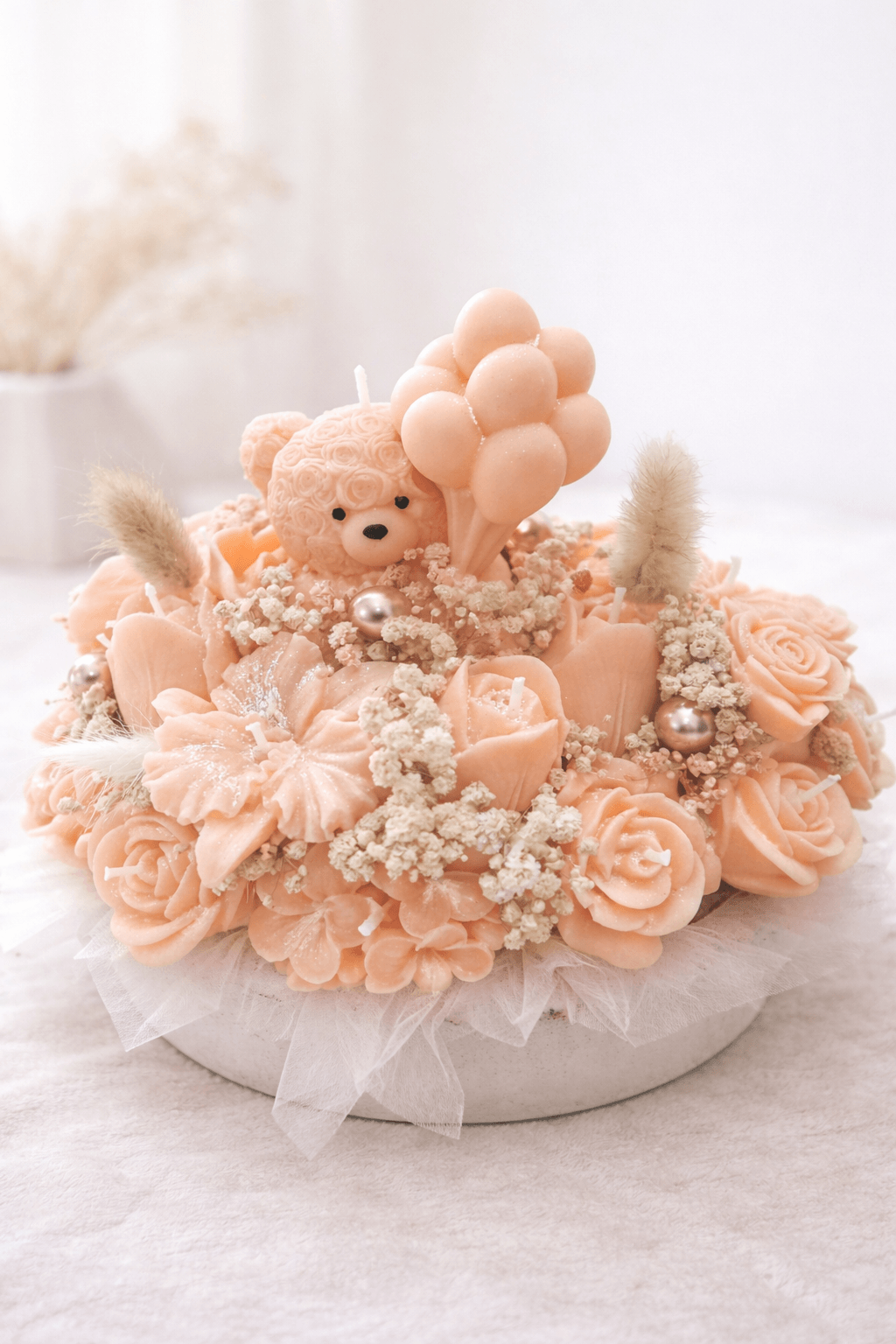 Handmade peach floral candle bouquet with teddy bear detail in ceramic base