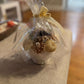Floral candle bouquet — orange & ivory flowers, gift-wrapped in clear cellophane with cream ribbon