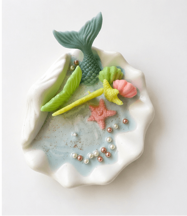 Handmade ocean shell candle with mermaid tail and marine decorations in ceramic base