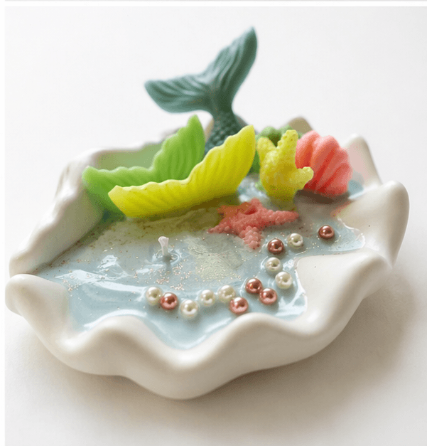 Handmade ocean shell candle with mermaid tail and marine decorations in ceramic base