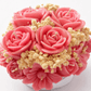 Handmade pink floral bouquet candle with rose-shaped wax flowers and decorative floral accents.
