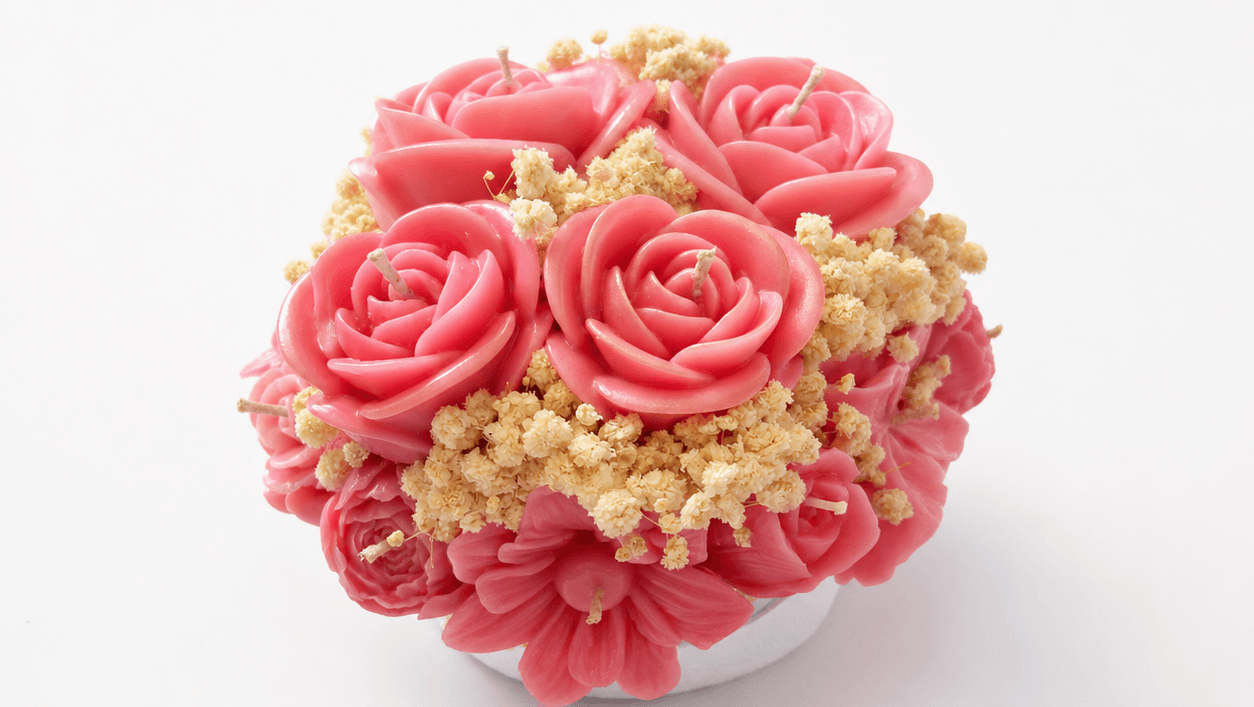 Handmade pink floral bouquet candle with rose-shaped wax flowers and decorative floral accents.