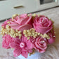 Handmade pink floral bouquet candle with rose-shaped wax flowers and decorative floral accents.