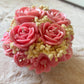Handmade pink floral bouquet candle with rose-shaped wax flowers and decorative floral accents.