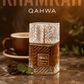Khamrah Qahwa bottle with a cup of coffee and mint leaves on a marble surface.