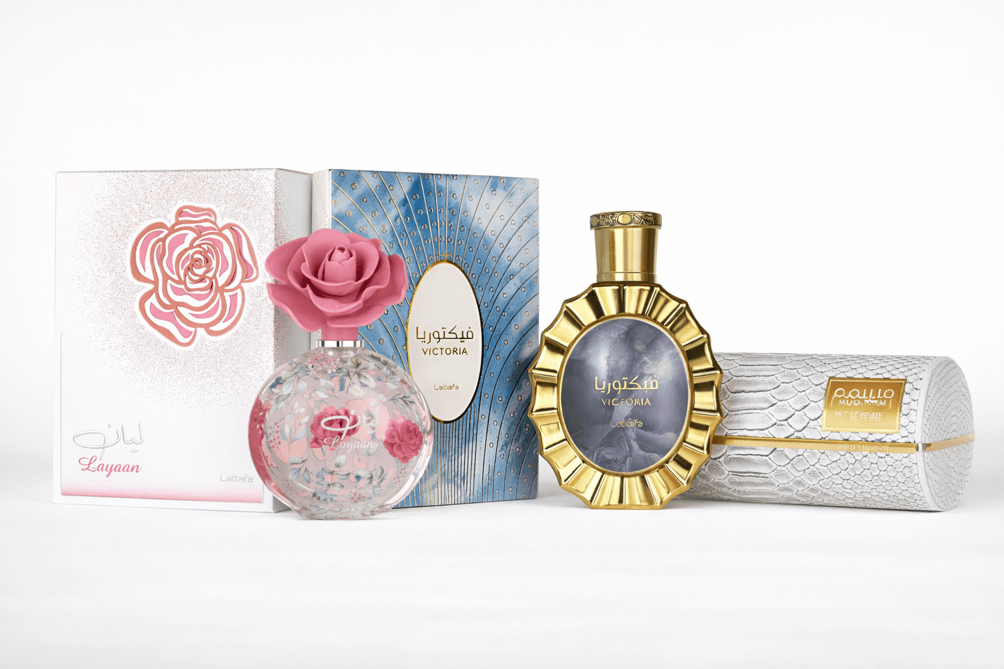 Lattafa fragrance bundle featuring Layaan, Victoria, and Musamam perfumes displayed on a clean white reflective surface