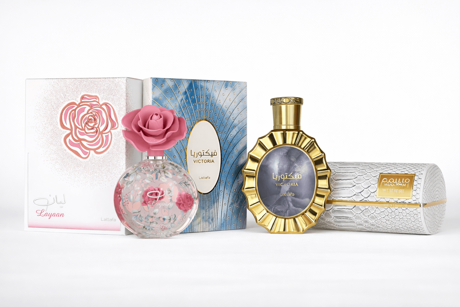 Lattafa fragrance bundle featuring Layaan, Victoria, and Musamam perfumes displayed on a clean white reflective surface