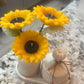 Sunflower candle arrangement — three yellow sunflower candles in ribbed ceramic vase with matching lidded jar on tray