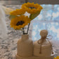 Sunflower candle arrangement — three yellow sunflower candles in ribbed ceramic vase with matching lidded jar on tray